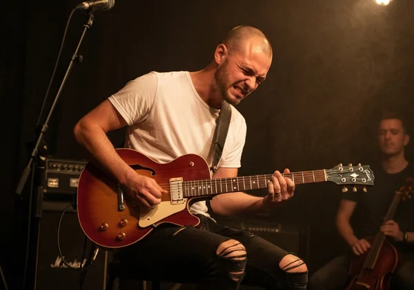 Guitarist with off-key notes, highlighting intonation issue