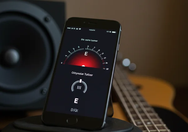 An online guitar tuner on a phone showing a perfect tune.